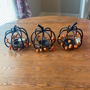 Set of three metal 3-D pumpkin votive holders with pumpkin candle ring.